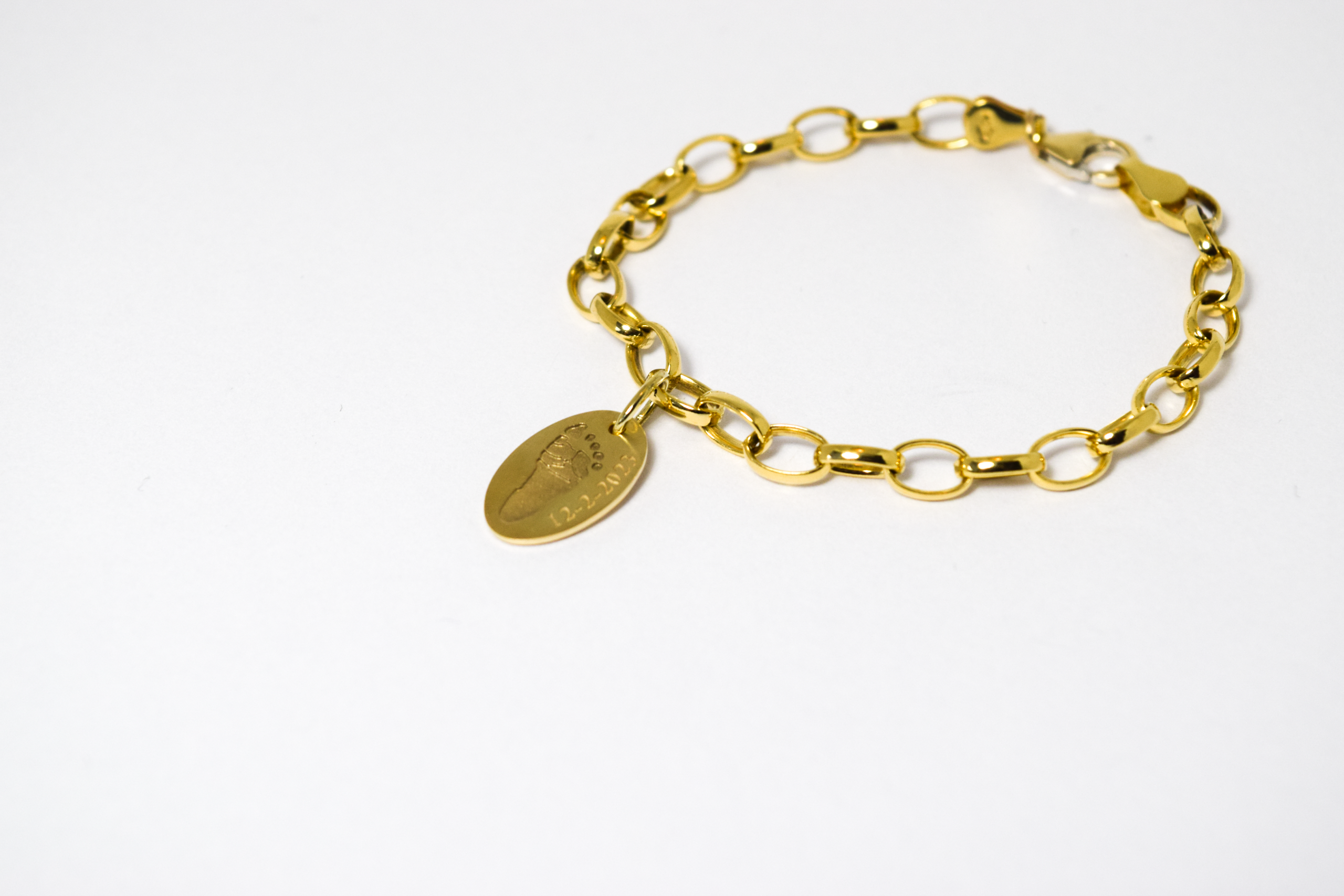 Gouden armband met bedel met voetafdruk baby en datumgravure van geelgoud door Teuns Design Wijchen