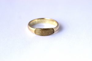 Geel gouden trouwring met een toegevoegde vingerafdruk - sieraden vermaken door goudsmid Teuns Design